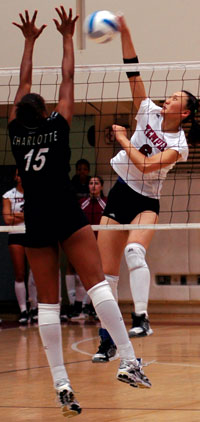 Sophomore Yue Liu tries to spike the ball over an opponents hands.